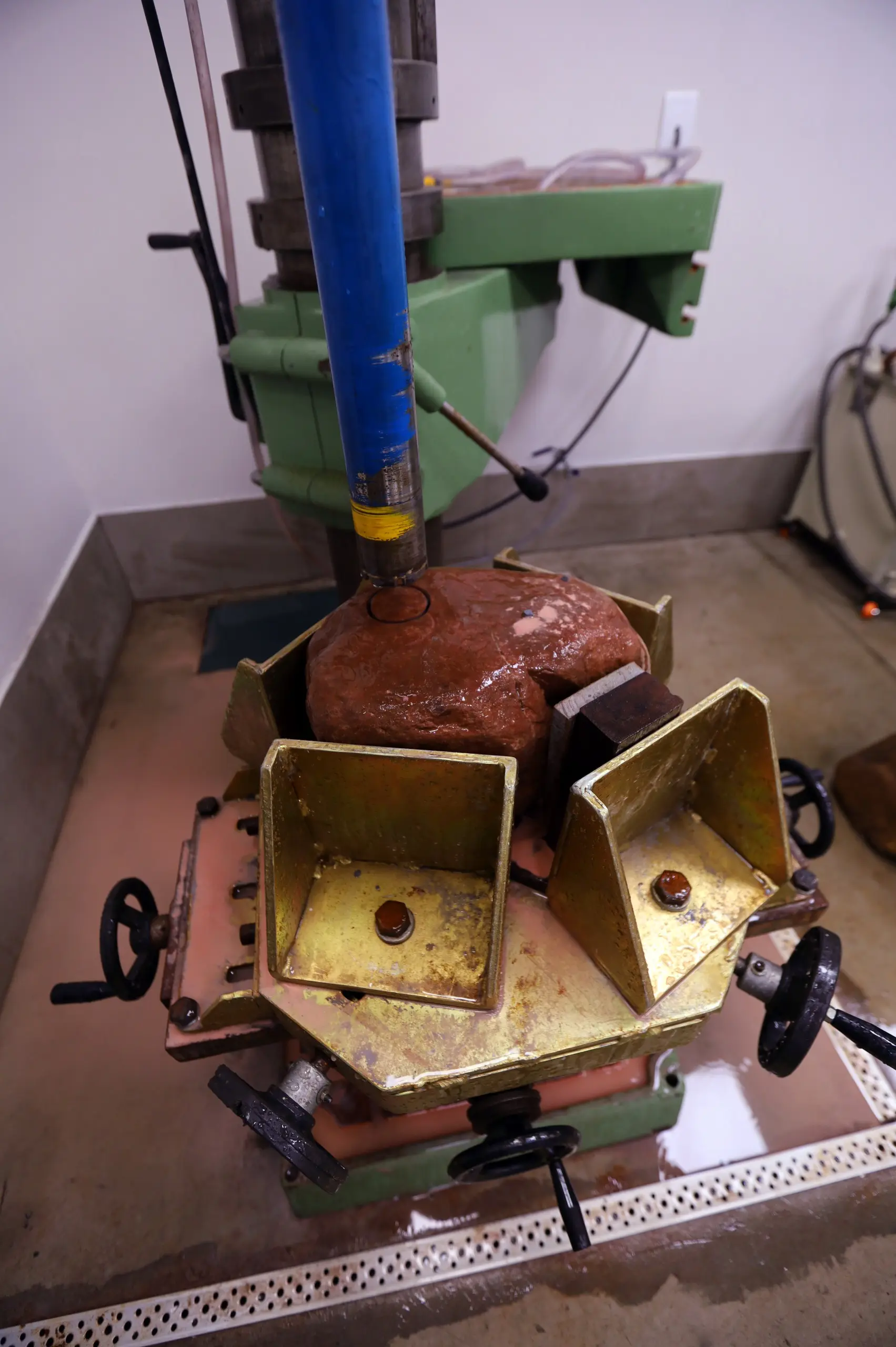 Perfuratriz de bancada extraindo corpo de prova de rocha